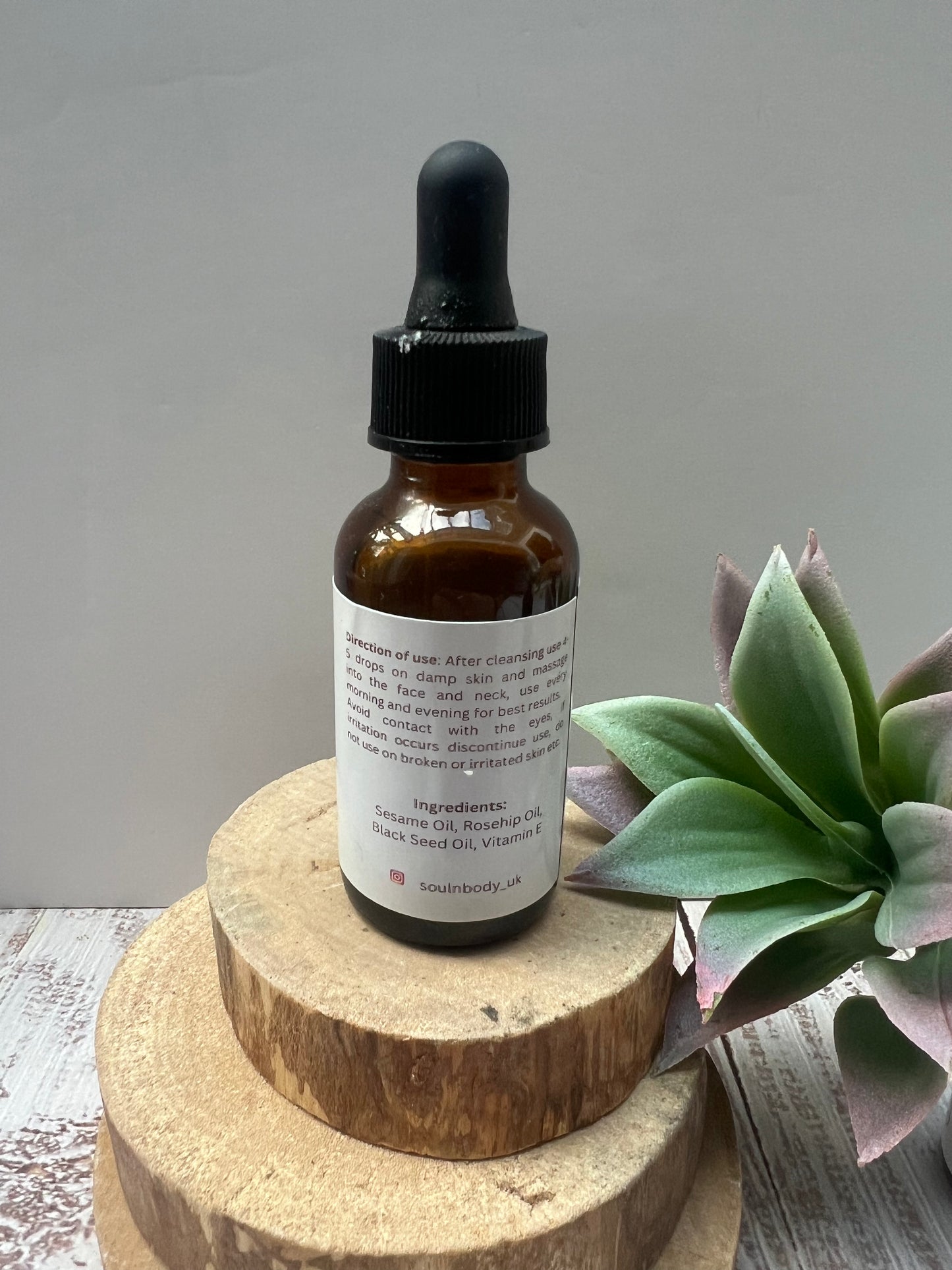 Close-up of golden Restorative Face & Body Oil dropper showing rich, nourishing texture.