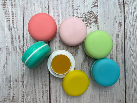 Colorful macaron cookies on a wooden surface filled with lip balm