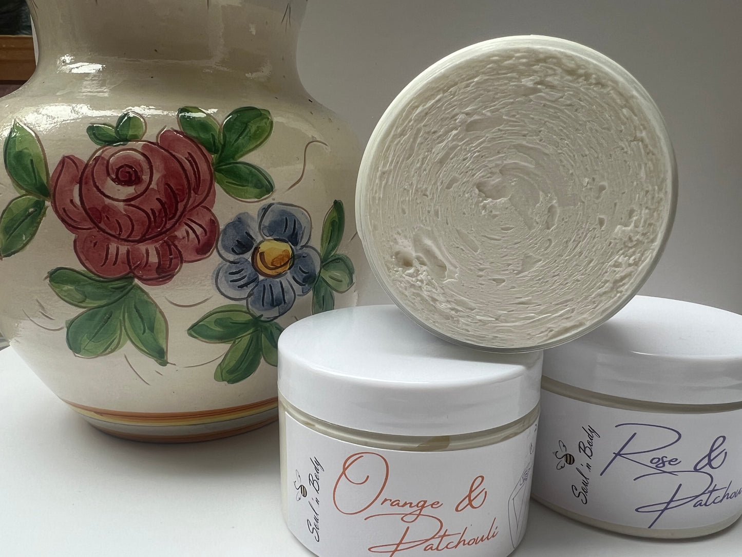 Jar of whipped body butter on table with lid off