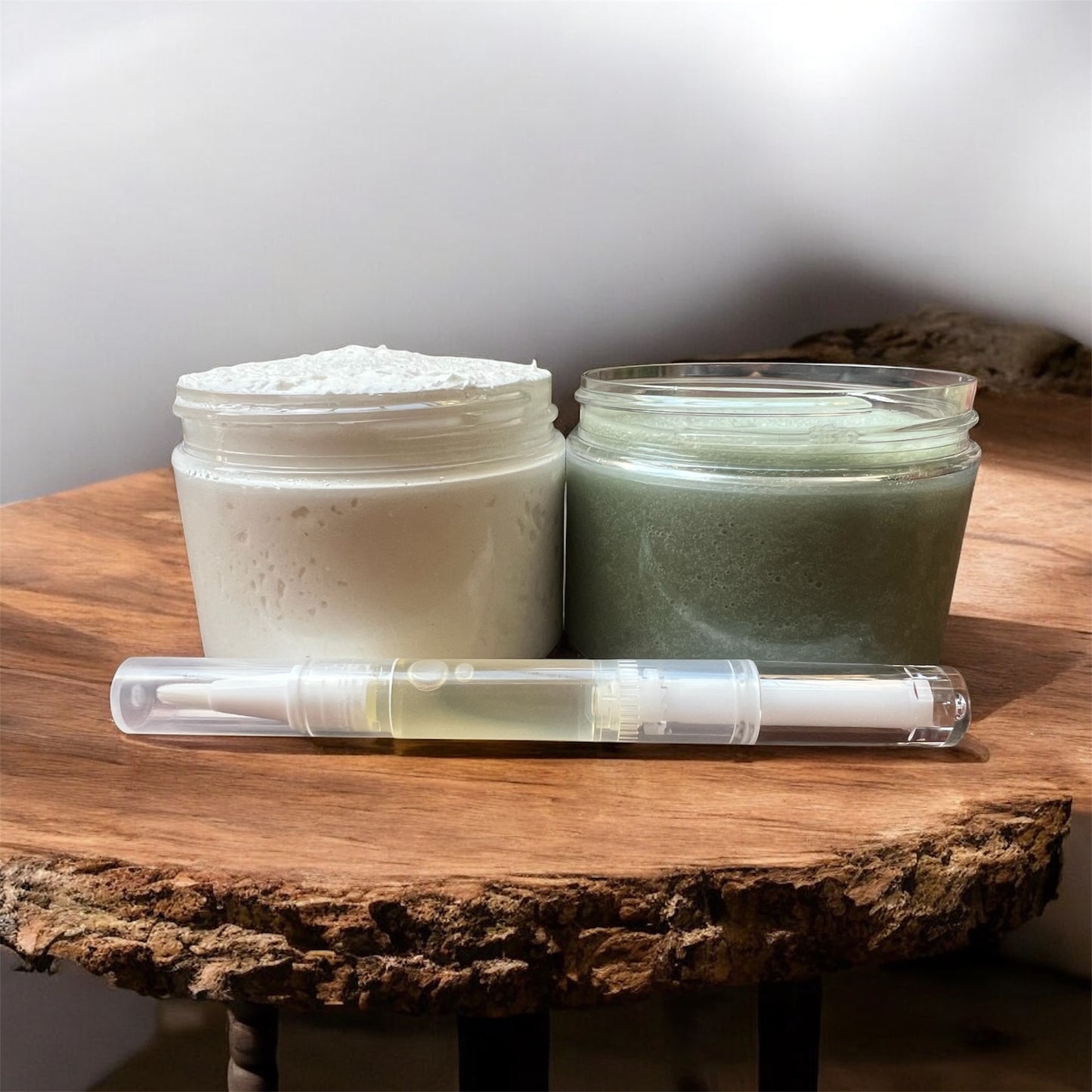 natural foot care set with whipped butter, green exfoliating scrub, and nourishing nail oil on wooden board.