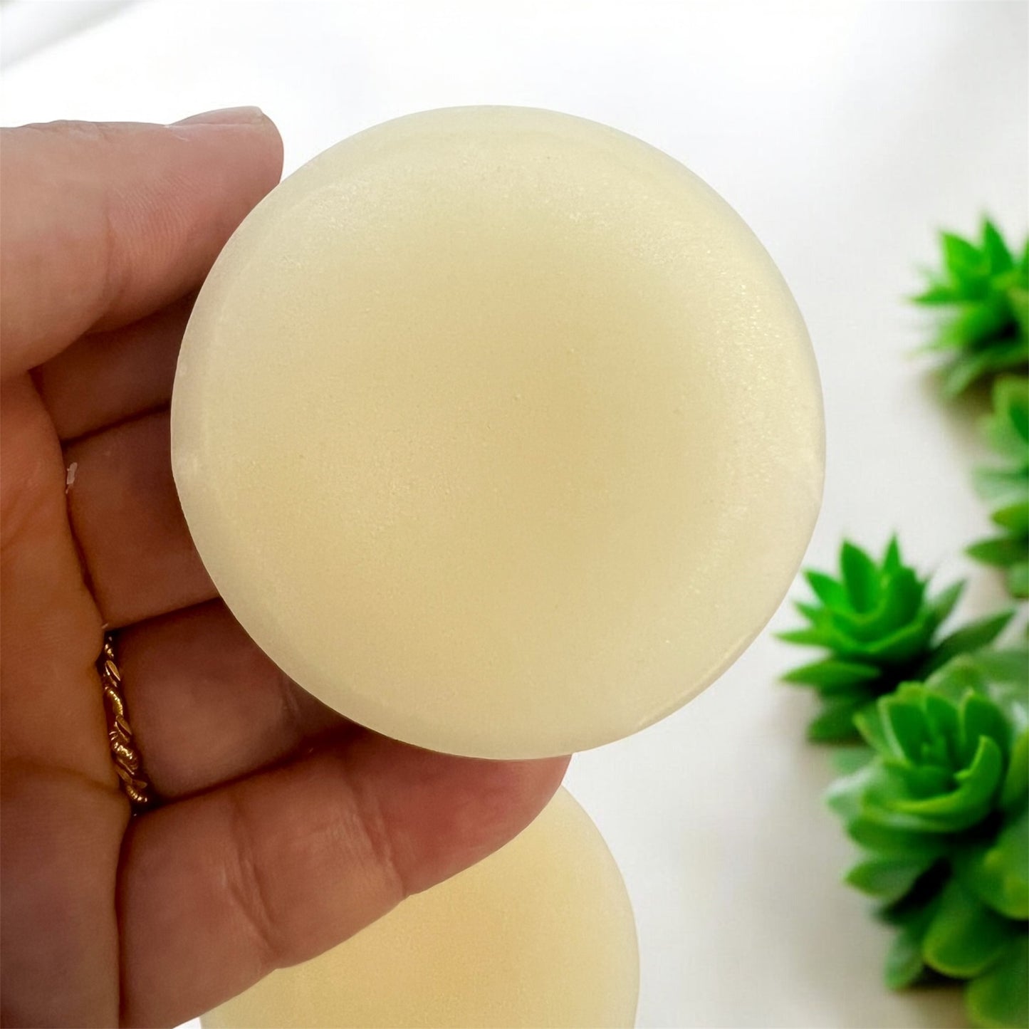 Hand holding Solid conditioner bar eco-friendly and plastic-free hair care option.