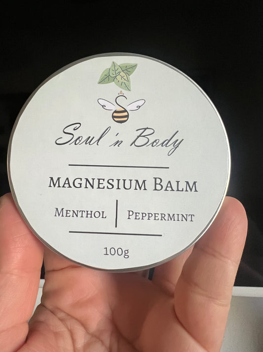 Soul 'n Body magnesium balm container held in a hand with a dark background