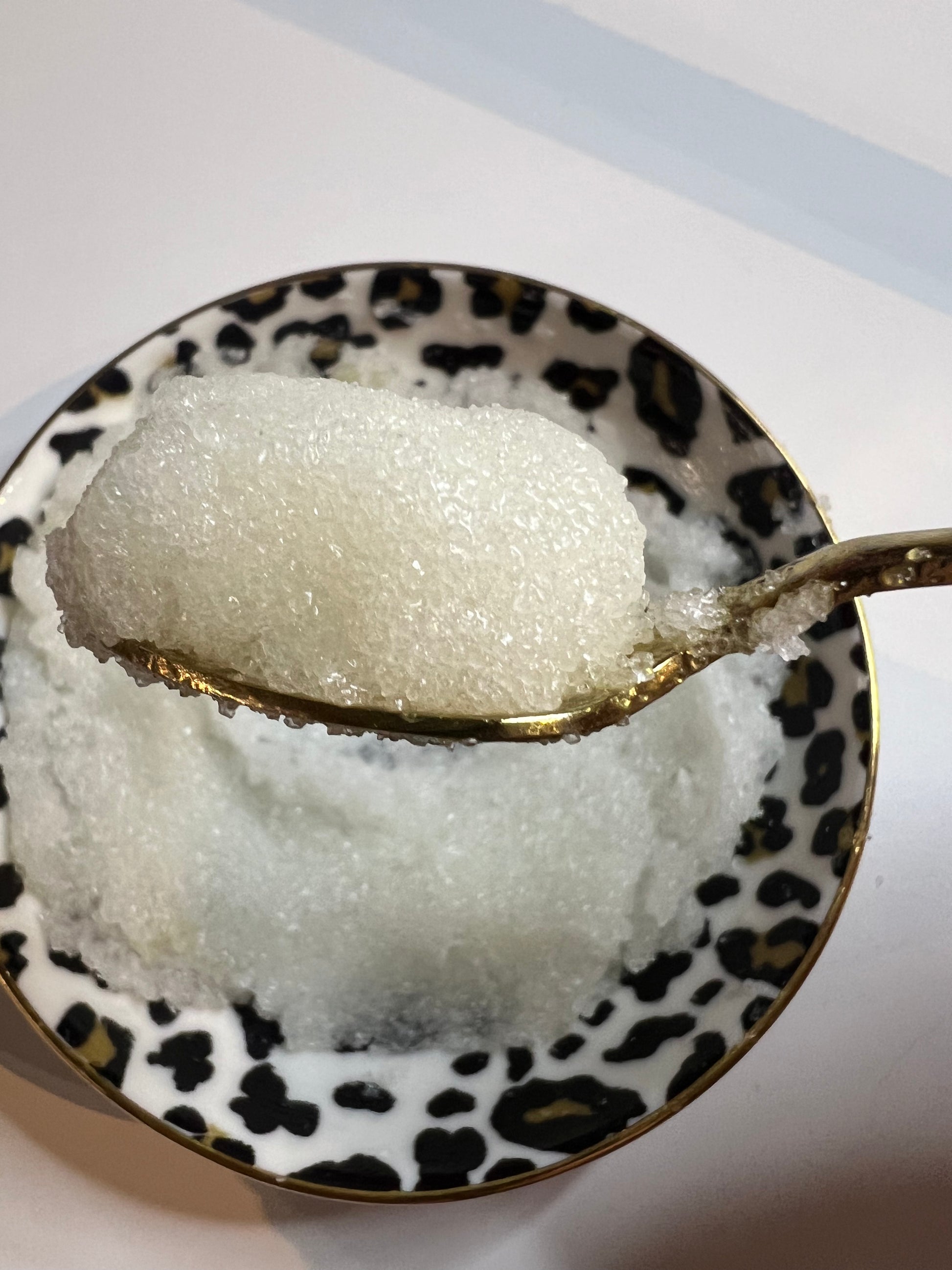 Exfoliating lip scrub texture shown on spoon – nourishing blend for soft lips