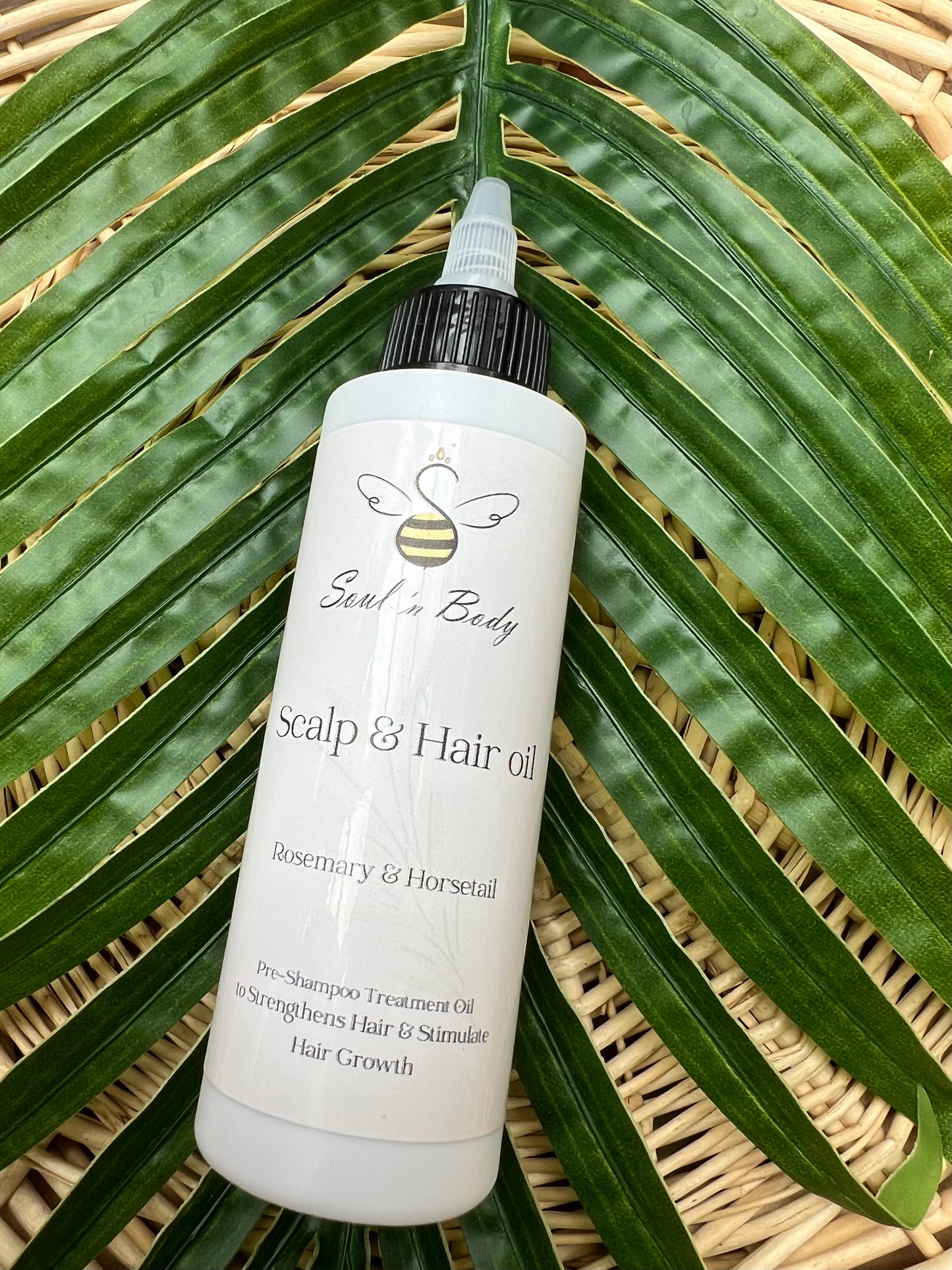 Bottle of Scalp & Hair oil on a leaf with 'Soul n Body' branding
