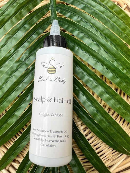 Bottle of Soul n Body Pre-Shampoo Hair & Scalp Oil placed on large green palm leaves.