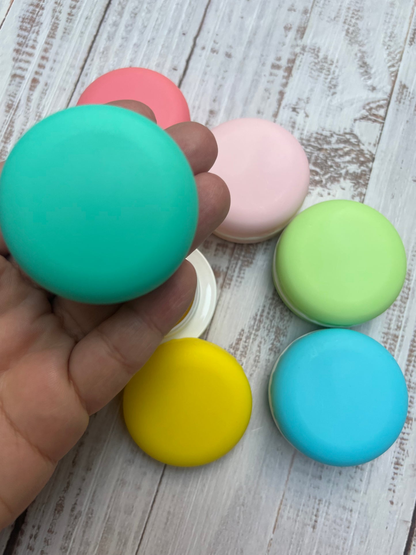 Colorful macaron-shaped objects on a wooden surface