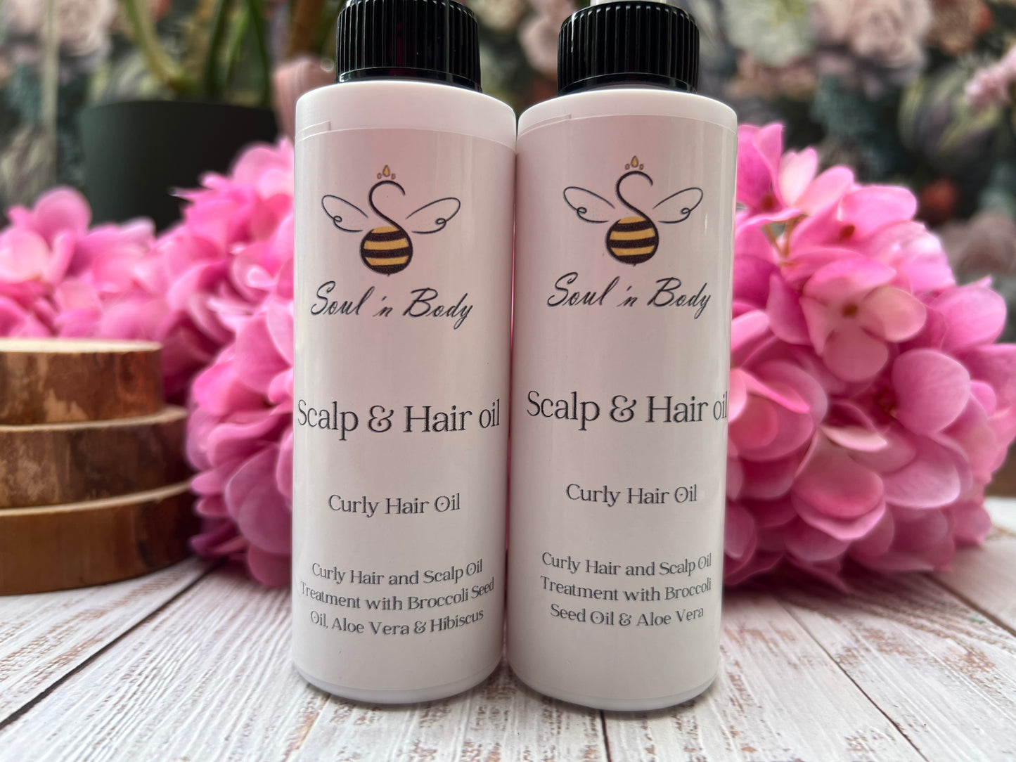 two bottles of curly hair oil with broccoli seed oil