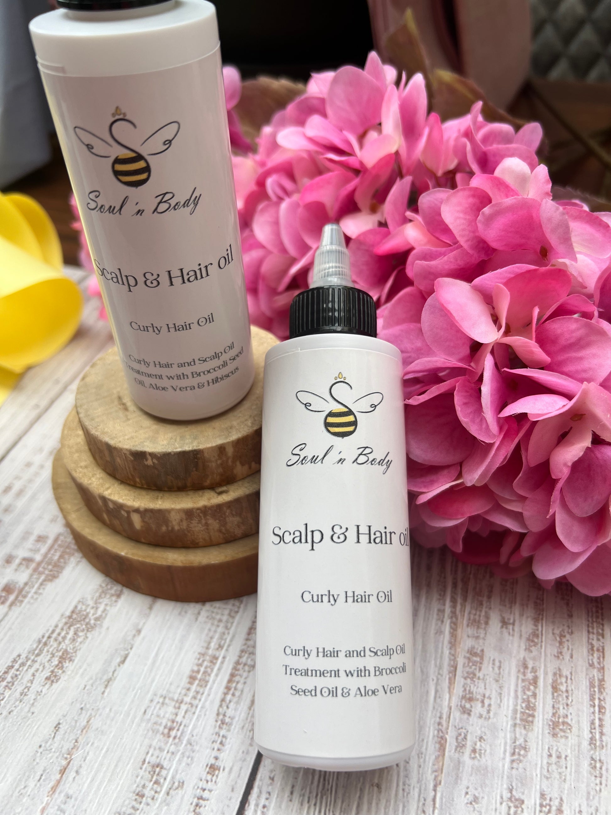 two bottles of hair and scalp oil for curly hair