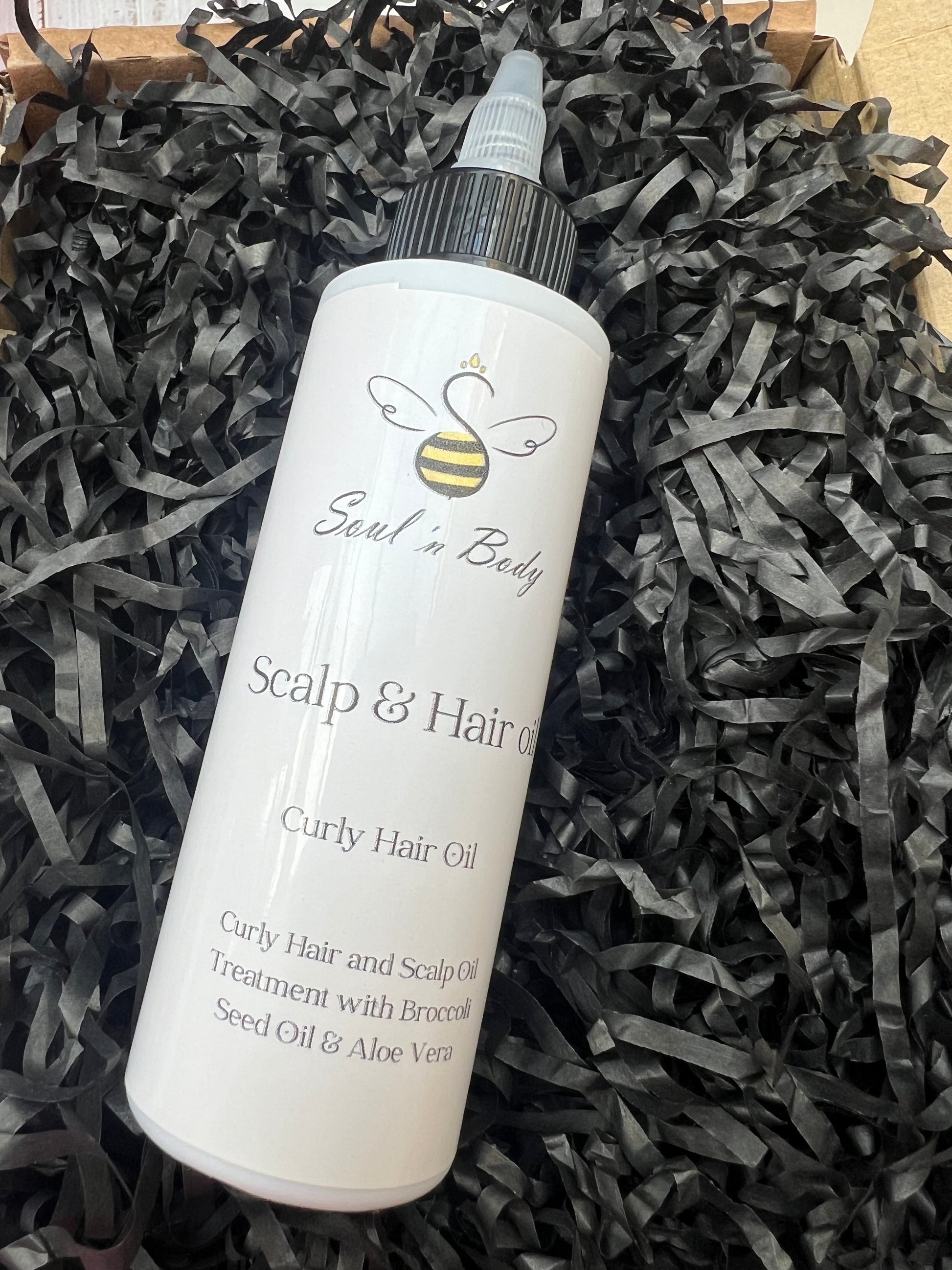 Bottle of Scalp & Hair Oil from soul n body on a black shredded paper background