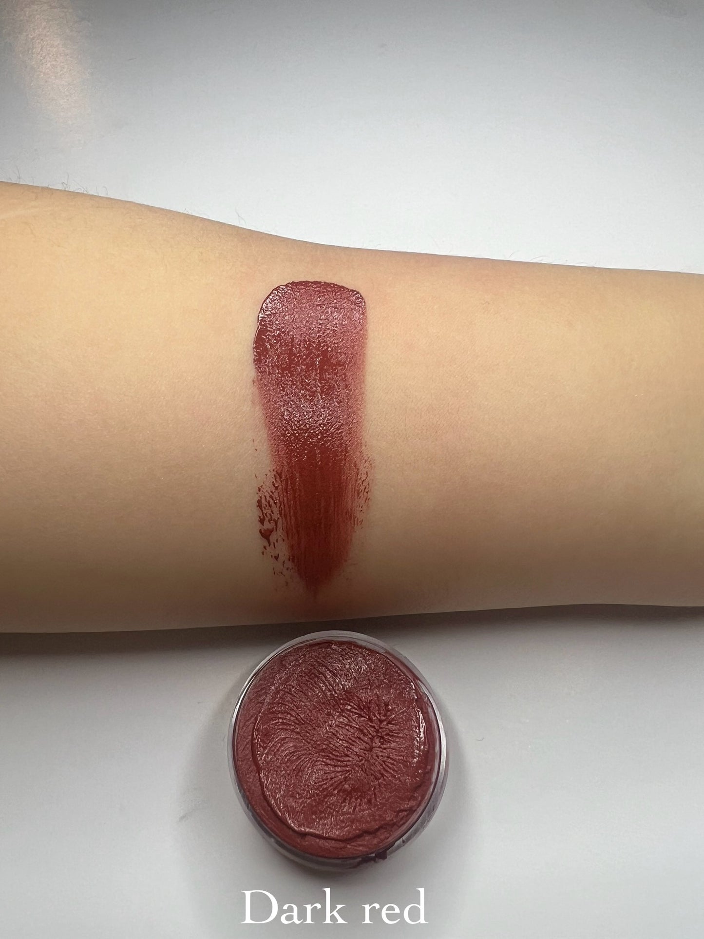 Tinted lip balm swatch in Antelope Pink shade on skin, rosy shimmer glow