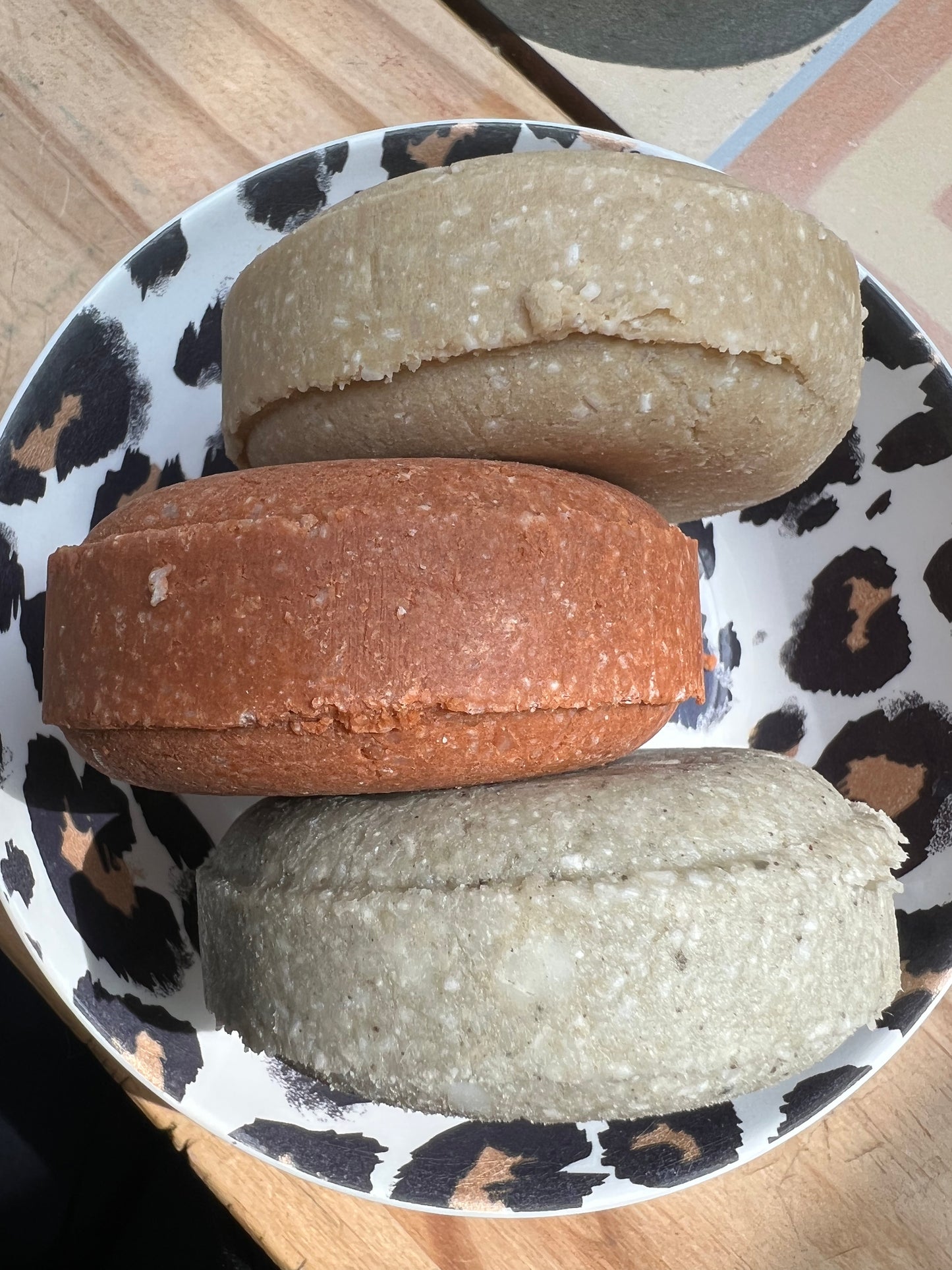 Assorted clay shampoo bars in red and cream shades