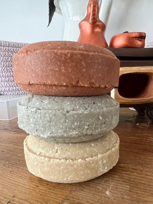 Stack of handmade clay shampoo bars in natural colors