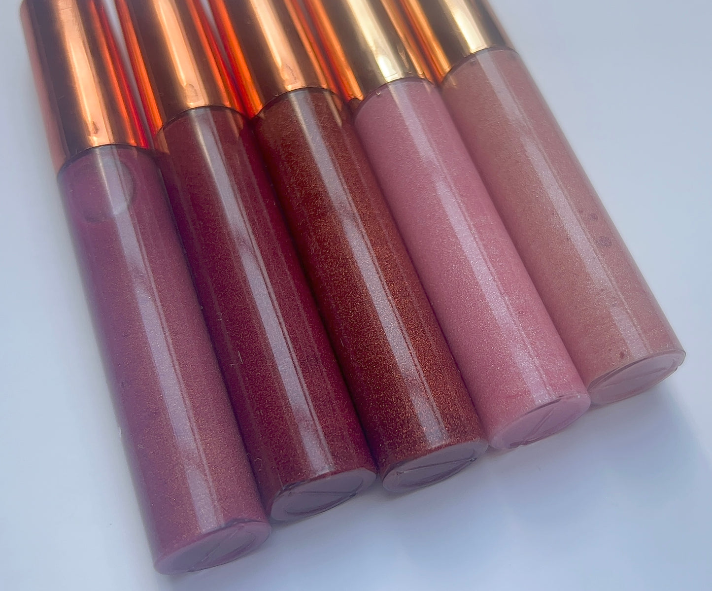 Set of 5 handmade natural lip glosses in red and pink shades – moisturizing, glossy, and non-sticky finish.