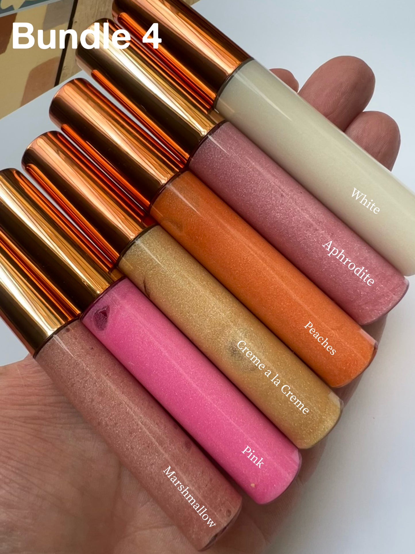 Bundle of 6 handmade natural lip glosses – White, Aphrodite, Peaches, Crème à la Crème, Pink, and Marshmallow – moisturizing, glossy, non-sticky finish.