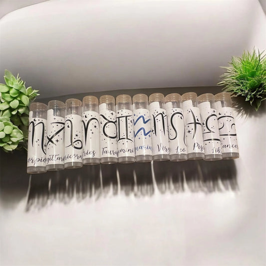 Handmade zodiac lip balms displayed on rustic wooden background with green succulents